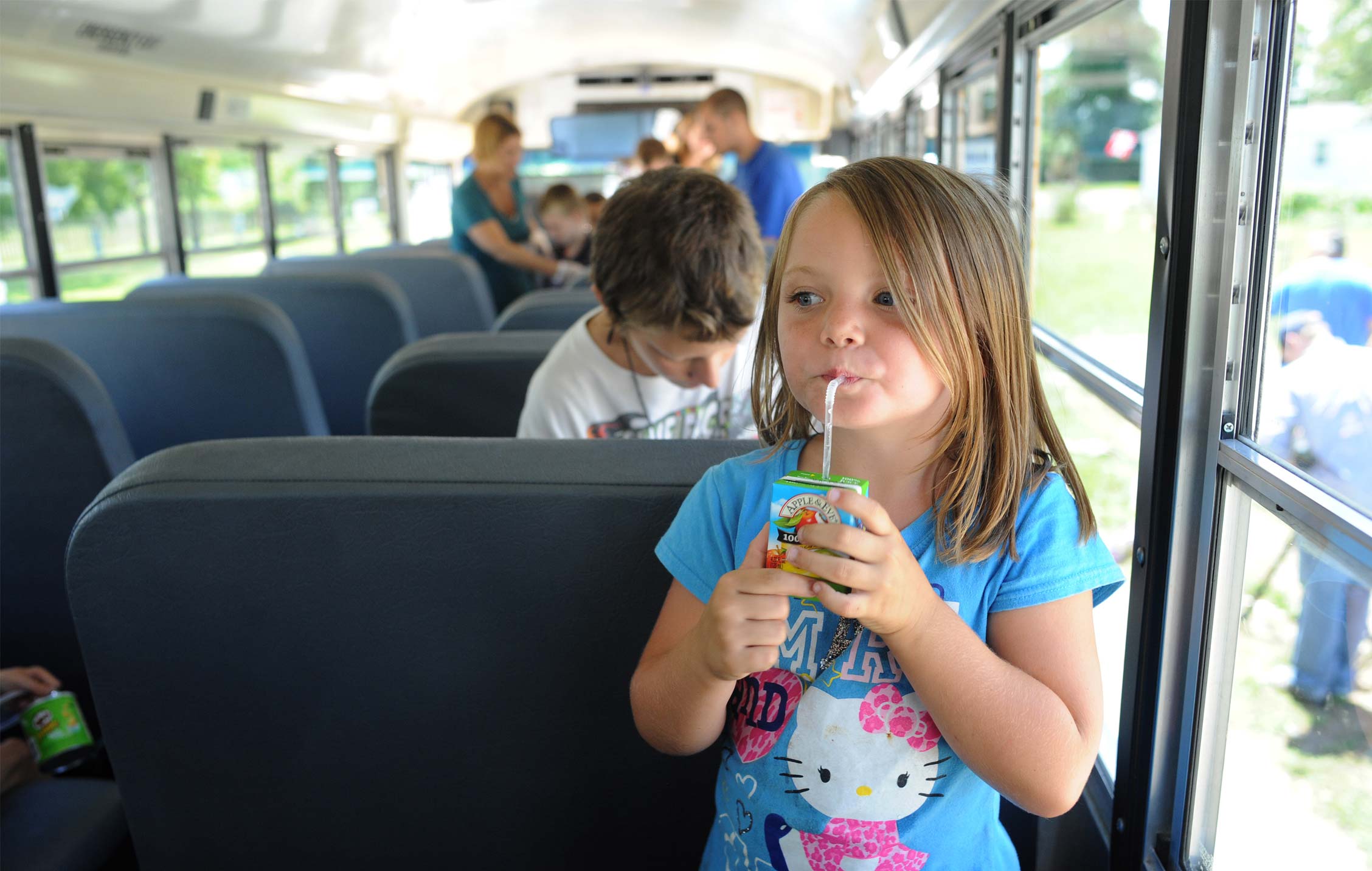 A young girl on a bus, stop summer slide 